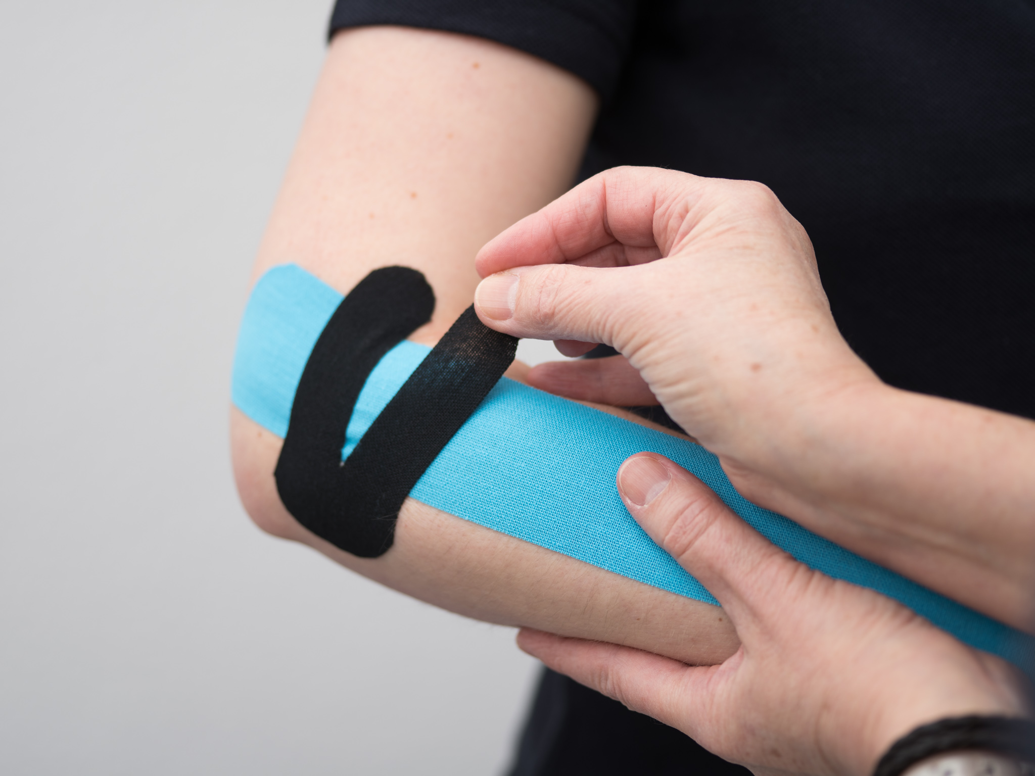 Praxis_Herzberg_Guenther_93 Abbildung Kleben eines Kinesiotape für das Thema "Wahlleistungen" (Selbstzahlerleistungen)